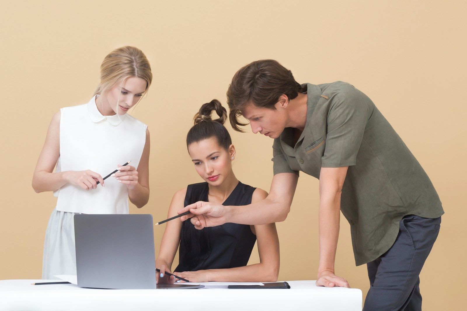 Professionals collaborating around a laptop